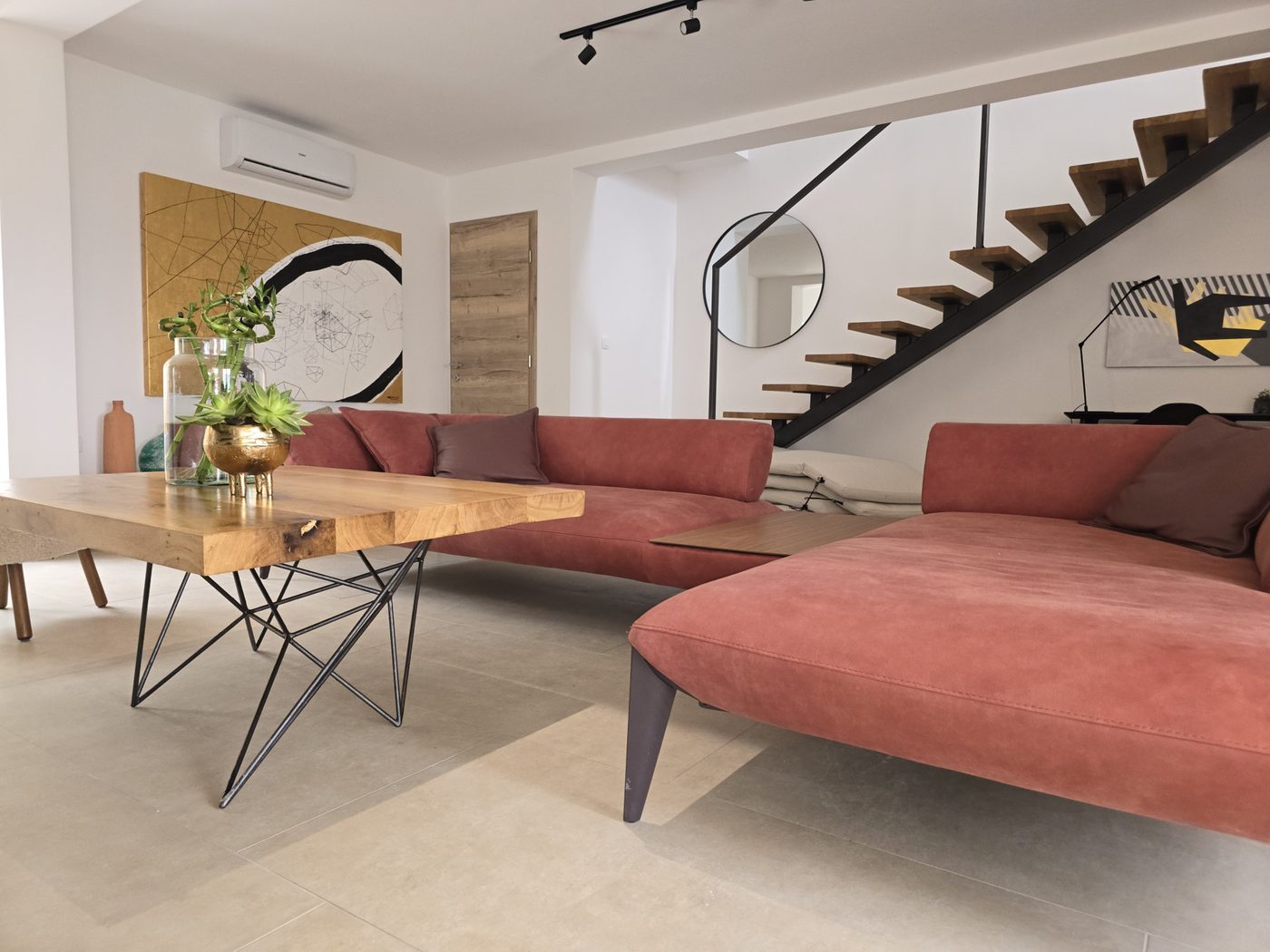 Open living room with a long dining table and an open staircase